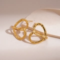 Detail of 18k gold plated hollow heart-shaped knotted earrings on stone display - Gold (925 Sterling Silver Earring Post)