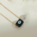 Macro del ciondolo rettangolare Malocchio su una sottile catena di collana dorata - Nero