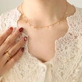 Elegant 18K gold plated star pendant necklace and layered ring set on female model - Gold Star Style