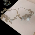 Macro view of silver heart hoop earrings with butterfly accents and sparkling crystals - Silver Butterfly Pave