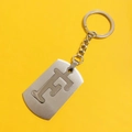 Close-up of stainless steel keychain with hollowed-out letter E design on yellow background - Letter F