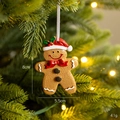 Christmas gingerbread man ornament with red hat and white string on a tree branch - New Red Fruit Gingerbread Man