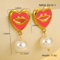 Détail macro de boucles d'oreilles cœur dorées avec motif lèvres et perles - Or