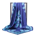 Detail showing the elegant drape and glossy paisley pattern of the blue silk scarf - 90*90cm / Sapphire Blue