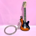 Detail of guitar keychain with orange gradient finish and silver metallic chain - Orange