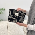 Detailed texture of black and white plush cosmetic bag with colorful dot pattern - Ethnic Style Totem