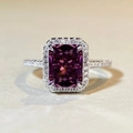 Macro-opname van zilveren ring met fuchsia edelsteen in kussenslijpsel en halo-zetting - US 5 / Karmijnrood