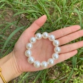 Elegant white faux pearl bracelet with elastic band shown in a natural outdoor setting - Small Pearl