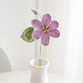 Dettaglio di un fiore viola fatto a mano all'uncinetto con foglia in un vaso bianco - Viola