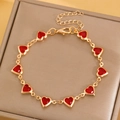 Chic gold-tone bracelet featuring multiple red heart gemstones on a soft display cushion - Red Heart Bracelet (4940)