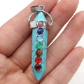 Macro view of natural crystal hexagonal prism pendant with seven colorful chakra stones - 7 Chakra Blue Turquoise