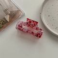 Detailed macro view of large pink marble acetate hair claw clip on ceramic plate - Large Square Claw / Blood Red