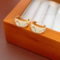 Dettaglio di orecchini a cerchio vintage a C con smalto bianco e motivi geometrici - Bianco