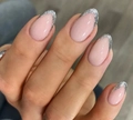 Macro shot of oval almond press-on nails with nude base and silver glitter V-French tips - Light Pink Silver Glitter V-Shape French Tip (AW186)