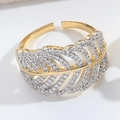Macro detail of a gold feather open ring featuring pavé set sparkling zirconia stones - Gold Leaf Feather Pavé Style