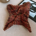 Dettaglio di uno scrunchie in tweed rosso e nero con fili metallici dorati su superficie - Stile con paillettes quadrate rosse