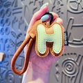 Letter H leather keychain in brown and mint green with litchi texture and stitching - Letter H