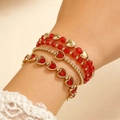 Detail van een vierdelige rood-gouden hartjesarmbandset gedragen om de pols - Hol Hart en Rode Kraal Stapel / Klassieke Roodgouden Stijl (DZ-208)