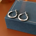 Minimalist silver hoop earrings presented on a dark blue textured jewelry box - 20mm / Silver