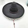 Dettaglio di un cappello di paglia messicano nero con pompon bianchi e cordino - M (56-58cm) / Diametro 35cm / Nero