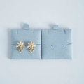 Detail of flower earrings with white pearls and rhinestones on light blue velvet card - Light Blue