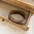 Detail of amber marble resin bangle displayed in a wooden drawer with fabric lining - Inner Diameter 66mm / Latte