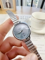 Silver chain watch on a magazine background showing the quartz dial and steel band - Blue