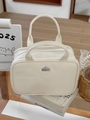 Detalle del neceser de cuero PU crema con doble cremallera y logo metálico de casa - Blanco