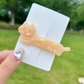 Detail of champagne orange acetate cat hair clip with pearl necklace and rhinestone eyes - Orange Cat