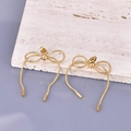Minimalistische 18K Gold Schleifen-Ohrringe an Schlangenkette auf strukturiertem Stein - 18K Gold