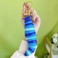 Blue jointed worm keychain toy with golden ring and bell accessory in hand - Caterpillar - Blue