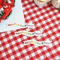 Close-up of three Merry Christmas cake topper banners on red checkered tablecloth - Colored Letter Merry Christmas Banner