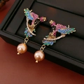Dettaglio orecchini a forma di uccello dorato con cristalli colorati e perla champagne - Orecchini di Perle di Pappagallo Multicolore (Perno in Argento Sterling 925)