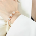 Roségoldenes Schlangenarmband mit kristallbesetzten runden Anhängern am Handgelenk - Z004-Armreif / Roségold