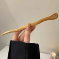 Vue détaillée d'une épingle à cheveux en bois ondulé tenue à la main avec grain naturel - Pic en Bois Ondulé / Couleur bois naturel