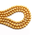 Close-up of golden faux pearl beads with metallic luster for DIY jewelry making - Gold
