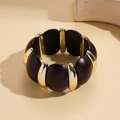 Nahaufnahme des Retro-Armbands aus Acryl und Goldmetall mit dunklen Harzkugeln - Kaffeebraun