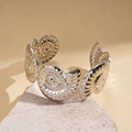 Detailed view of silver nautical conch shell spiral bangle on a natural stone base - Spiral Conch 3D Style