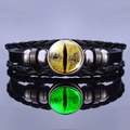 Detailed close-up of luminous dragon eye leather bracelet with polished metal beads and reflection - Yellow Reptile Eye Style