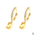 Dettaglio macro di orecchini a cerchio in oro 18K con ciondolo a goccia giallo e zirconi - Ovale Giallo