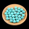 Blue-green turquoise 12mm half-hole beads scattered on a wooden tray for DIY jewelry - 12mm Synthetic Turquoise Semi Drilled Bead