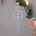 Detail of pink crystal suncatcher with gold moon charms and clear faceted glass prisms - Rose Quartz