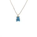 Collana dorata con ciondolo a forma di orsetto blu e cuore su sfondo bianco - Blu