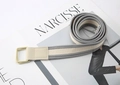 Close-up of gray and beige striped canvas belt with double ring buckle on a magazine - Grey & Beige Striped (Beige Buckle)
