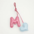 Close-up of pink leather letter M charm with blue heart and white stitching detail - Pink M with Light Blue Heart