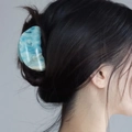 Pinza per capelli artistica in resina con motivo marmo blu e bianco su una modella - Blu Stellato Bianco