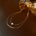 Detail of double-layer golden necklace featuring baroque pearl and curved metal bar - Double Layer Pearl Style / Gold