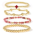 Stacked set of four gold beaded bracelets with a red cross charm and pink crystal beads - Deep Pink Gold 4-Piece Set