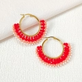 Detailed macro view of handmade watermelon-shaped seed bead earrings with gold hoops - Red