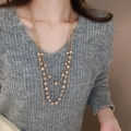 Detail of multi-layer gold necklace with champagne pearls on a grey V-neck sweater - Champagne Multi-layer Style (49#) / Gold-Pearl 8-12mm